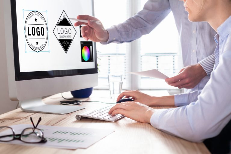 Two people collaborating on logo design using a computer.